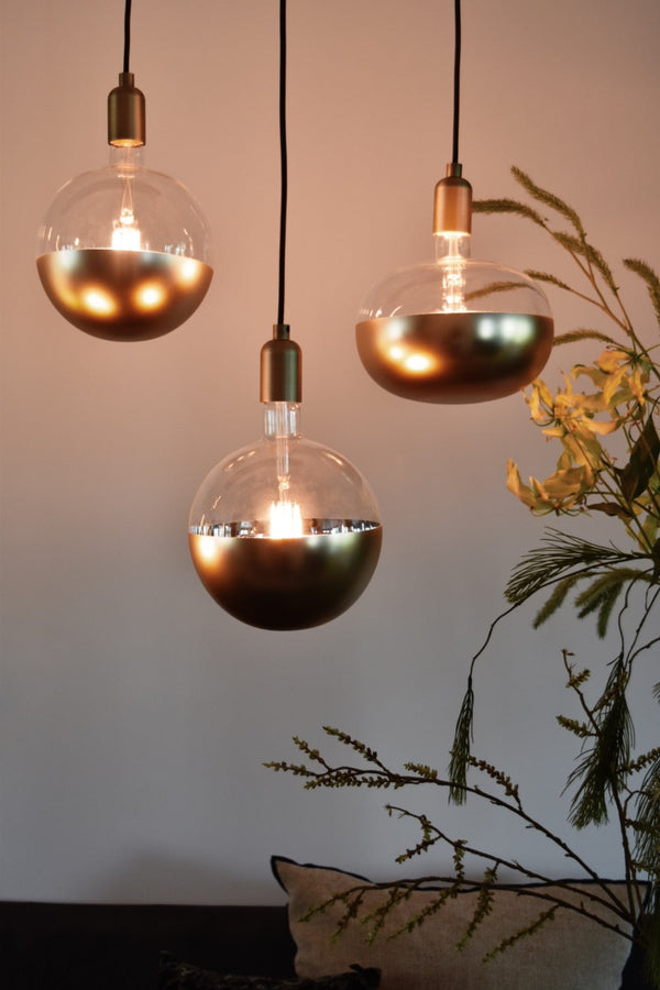 Sfeerafbeelding van drie duurzame LED hanglampen in goud